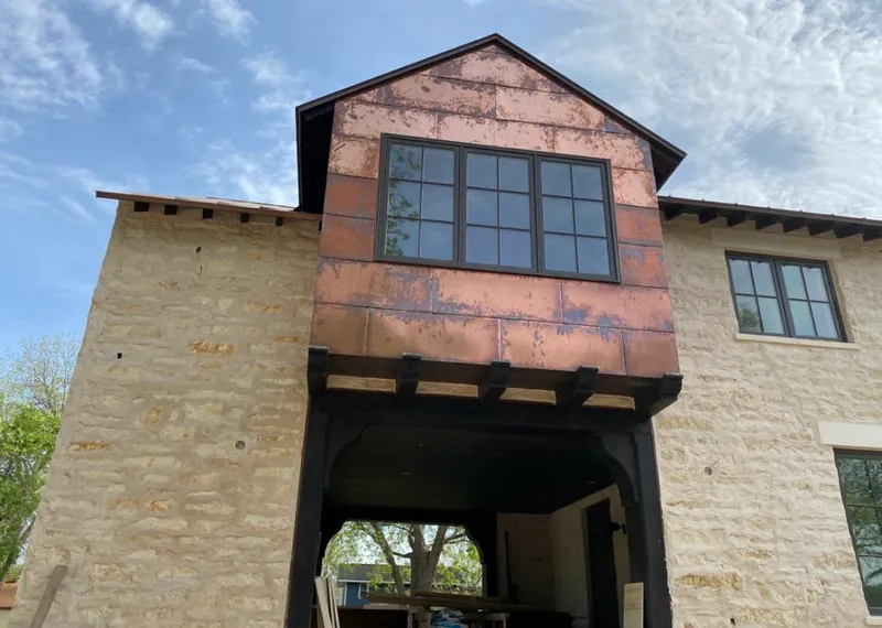 Copper metal panel facade on a stone building for Skylight Installation in Elma